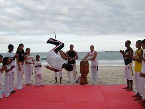 Capoiera, a mix of martial arts and cultural elements, being performed on the beach in Brazil.