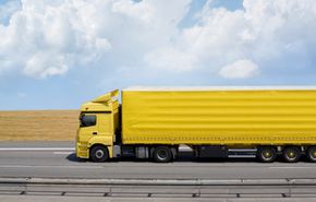 yellow tractor trailer on the highway