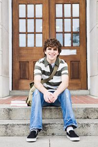 boy sitting on steps of school building