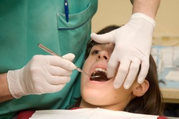 woman getting her teeth cleaned at dentist