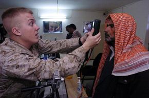 U.S. Marines take the retinal scans and fingerprints of Iraqi residents of Fallujah for their required biometric cards.