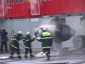 Airport firefighter trainees put out a simulated engine fire.