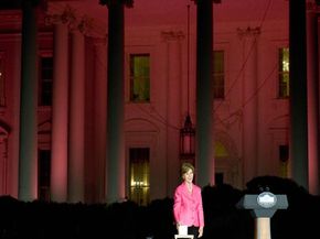 On Oct. 7, 2008, Laura Bush pushes a button to bathe the White House in pink light in honor of Breast Cancer Awareness Month.