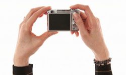 A person's hands holding a camera