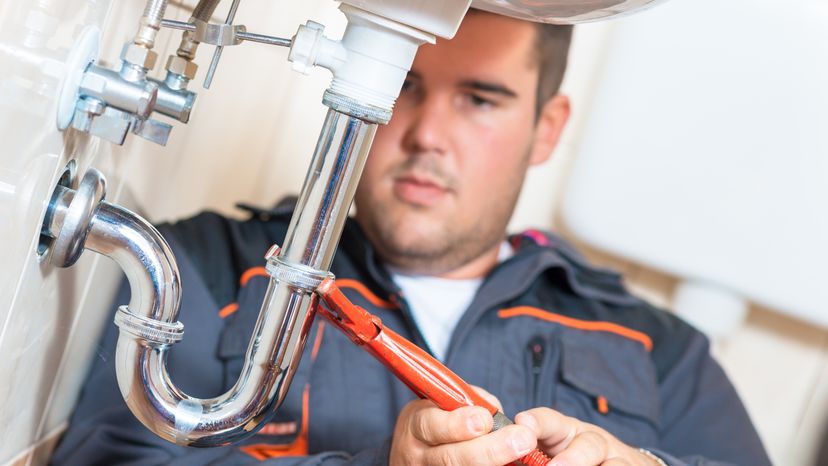 A plumber repairing drain of a sink