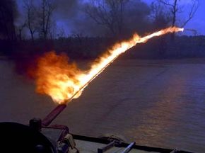 A U.S. Navy &quot;Zippo&quot; flamethrower is tested from a patrol boat. The unreliability of electronic ignition systems meant that operators sometimes had to use a Zippo lighter to ignite the fuel as it left the nozzle.