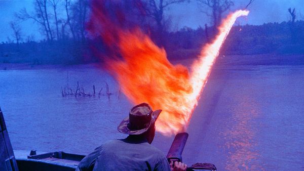 Man using flamethrower on boat.