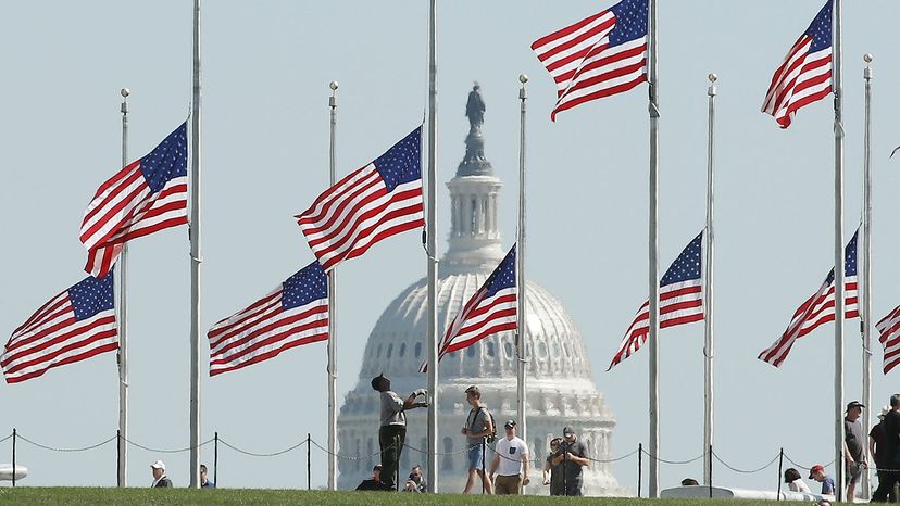 Park Service employee lowers U.S. flags 