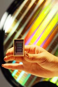 An employee of Samsung Electronics shows off the world's first 30-nanometer 64-gigabit Flash memory device during a news conference in Seoul, South Korea.
