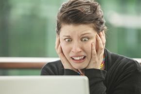 A girl showing frustration at her computer.