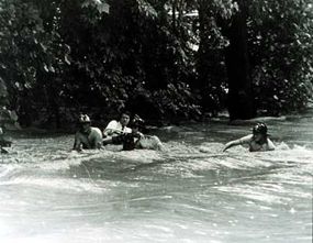 救援人员上游打击湍急的水流在1975年洪水袭击罗克维尔市,马里兰州。”border=