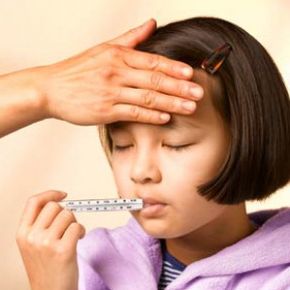 sick girl with a thermometer in her mouth