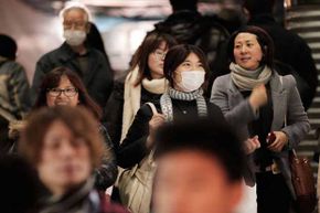 Commuters in Tokyo wear surgical masks to help protect themselves from an influenza outbreak.