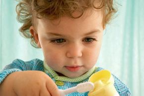 girl squeezing toothpaste onto toothbrush