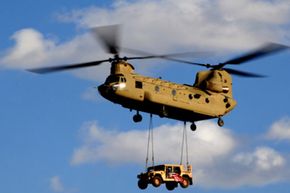 A U.S. Army CH-47 Chinook helicopter transports a Humvee.