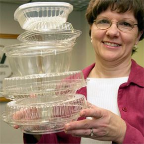 Woman displays corn plastic containers