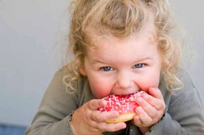 girl eating frosted donut