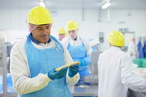 A worker inspects fish fillet on the production line of a seafood factory.
