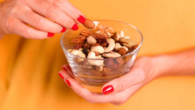 Close up of a girl hands eating nuts in a bowl