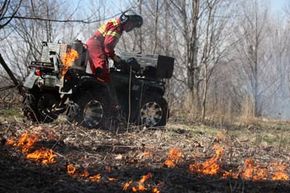 Worker ignites grasslands during a controlled burn