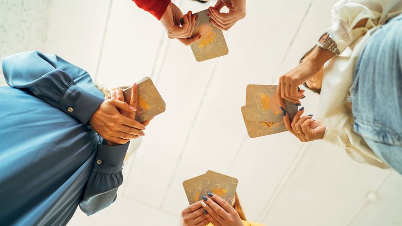 four woman hold tarot cards