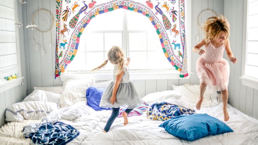 girls jumping on bed