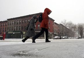 一对夫妇走到雪和冰雹的地铁在纽约的布鲁克林。”width=