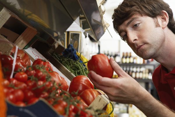 Man examining tomato