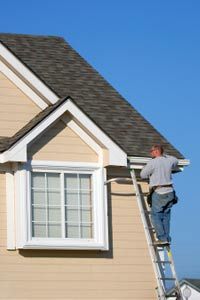 A workman fits a piece of extruded aluminum to the roof line of a house in Missouri.
