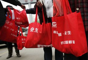 Chinese shoppers carry reusable bags because the government has announced a nationwide ban on free plastic bags in an effort to reduce crude oil consumption. Environmental initiatives are one example of a real-life public goods game.