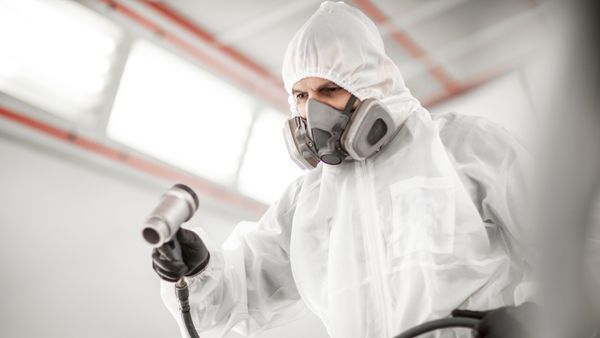 Car painter wearing a gas mask for safety