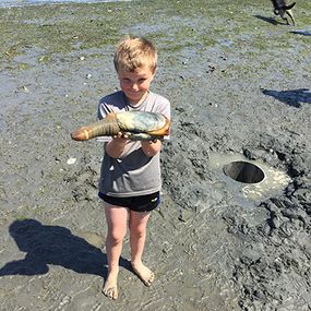 男孩握着他的第一个geoduck“border=