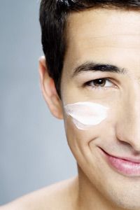 male close-up smiling face with cream on in studio