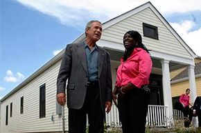 Former U.S. President George W. Bush speaks with new homeowner Joanika Davis at a mixed housing development in New Orleans. Developers of low income housing can get business tax credits.
