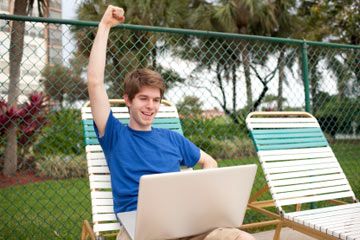 working on a computer by a pool