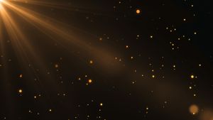 A ray of light shines down and illuminates golden specks in the air