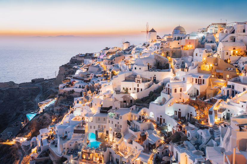 Oia, Santorini Island, Cyclades, Greece. Houses and churches, woman with a hat.