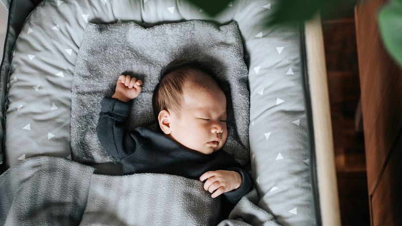 High angle shot of Asian newborn baby girl sleeping soundly in the crib at home