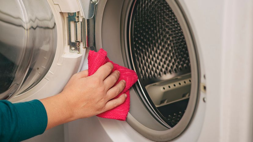 Hand holding a microfiber cloth to clean washing drum seal