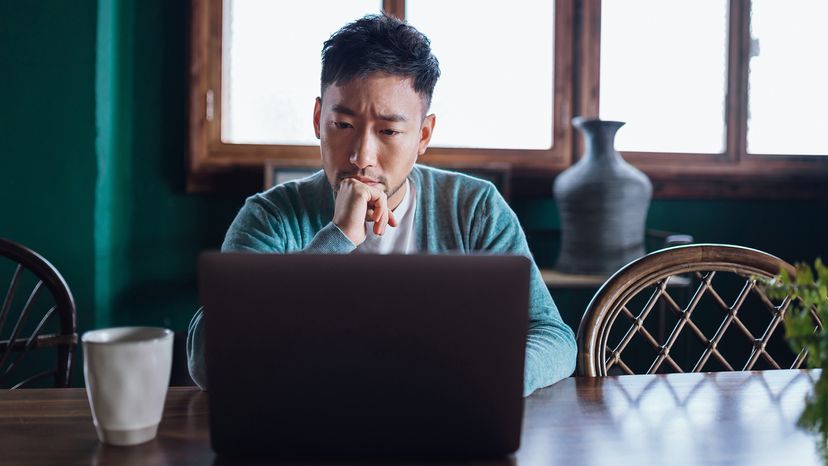 Young man concerned about private search looking at laptop