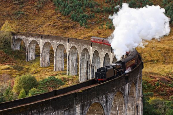 The Jacobite Express crosses a curved viaduct at Scotland's Glenfinnan.