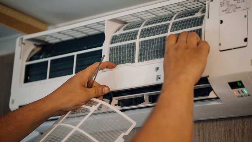 Hands changing the filter on an AC unit