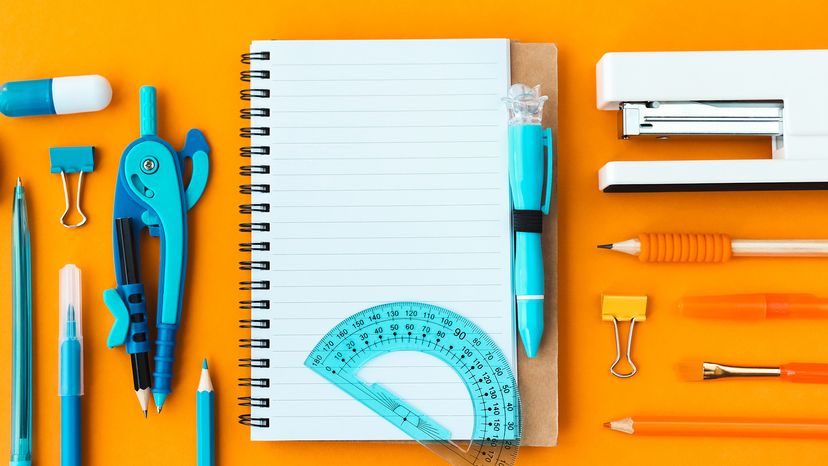 Top view of spiral notepad between blue, orange and white stationery