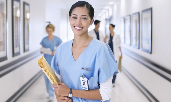 Portrait of smiling nurse in hospital corridor