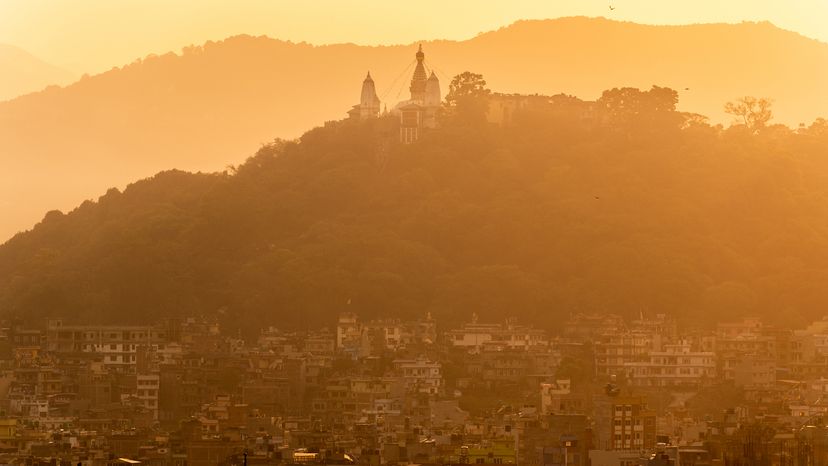 hazy yellow sky over city with mountain silhouettes