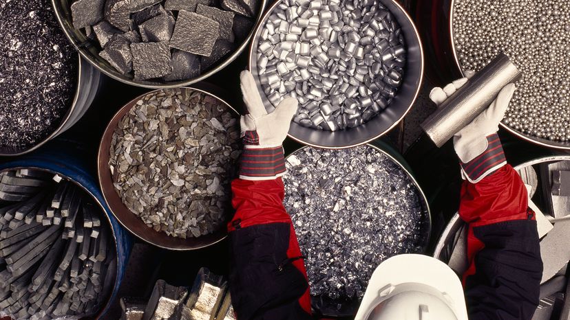 A worker sorts containers of metals and ores to be used for different applications.