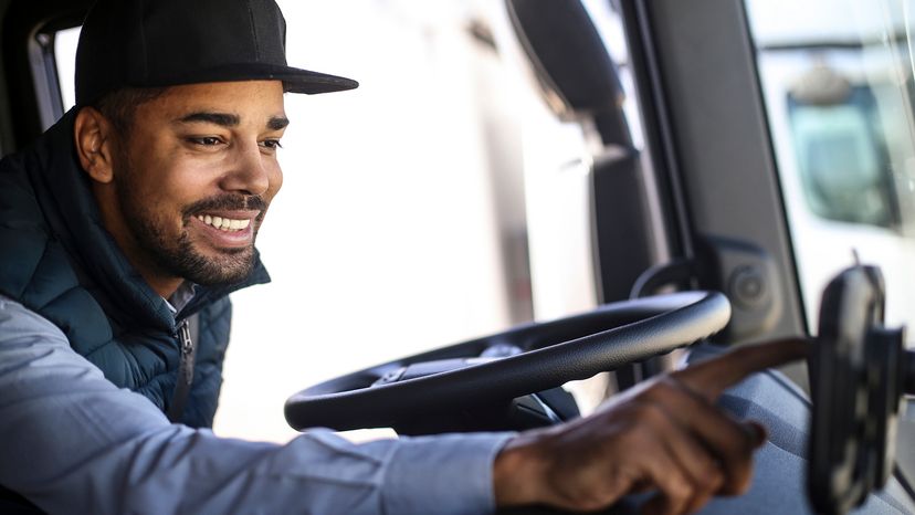 Truck driver smiling and using GPS navigation
