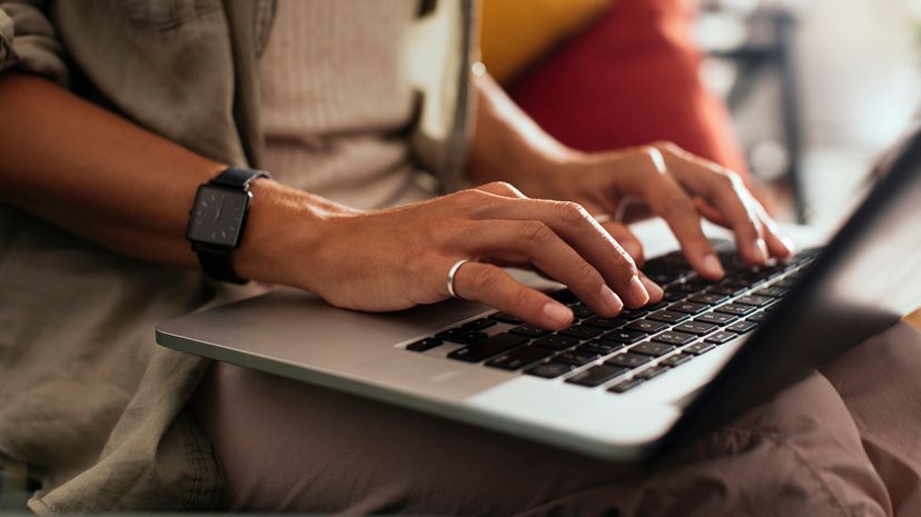 Close up shot of hands typing on laptop keyboard