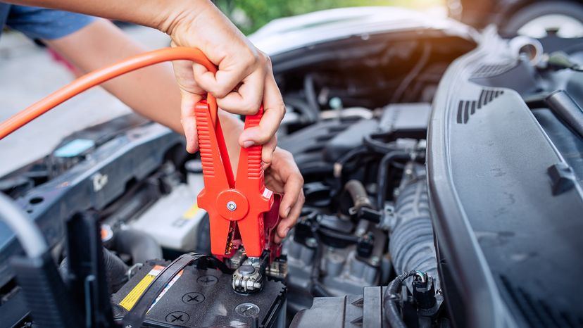 Close up of auto mechanic jumping battery car