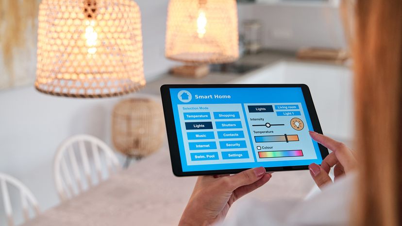 Woman using an app on her smartphone to control the lighting in her smart home